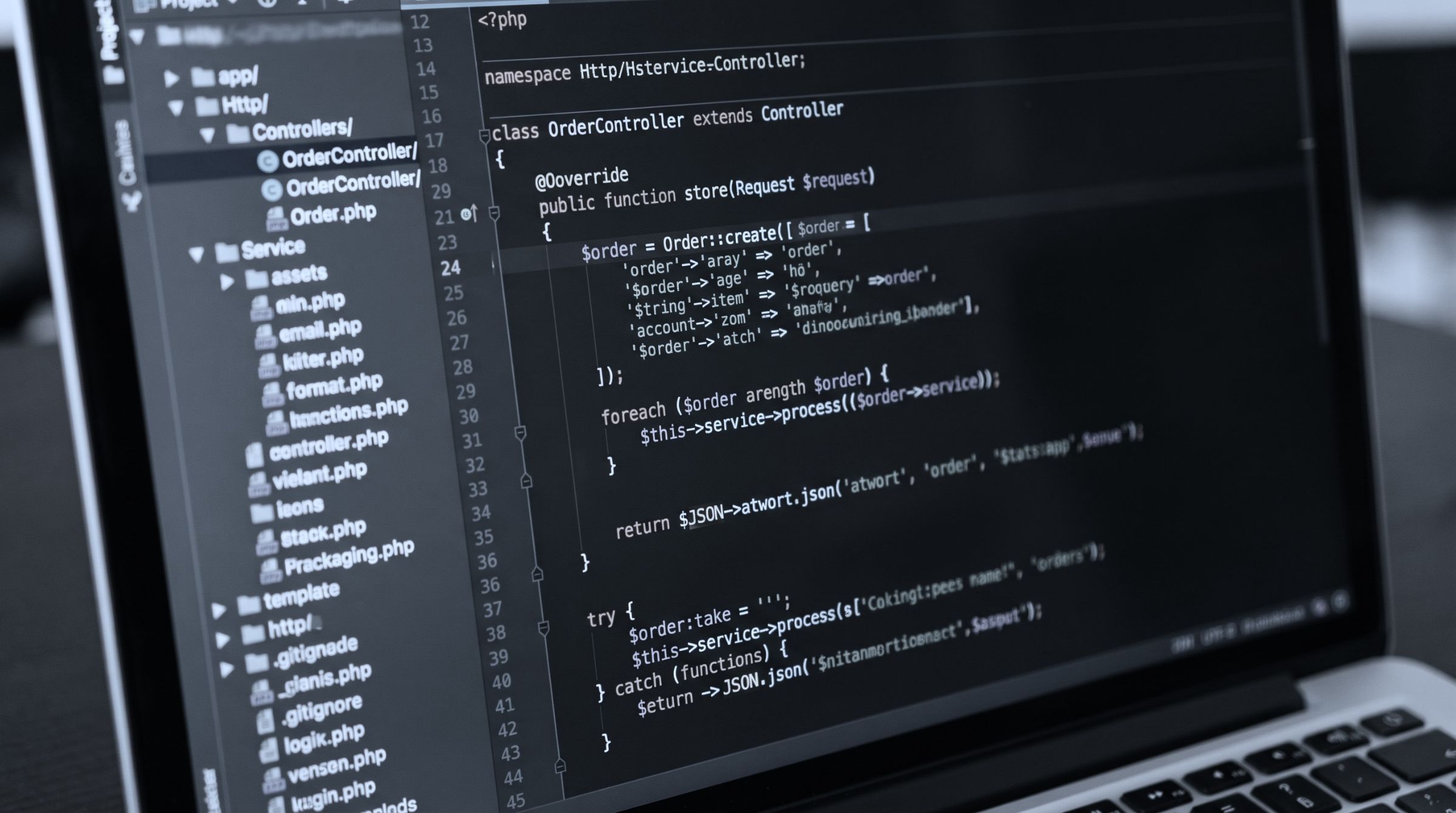 Aufgeklappter Laptop mit einem Code-Editor, der PHP-Quelltext und eine Dateiliste zeigt